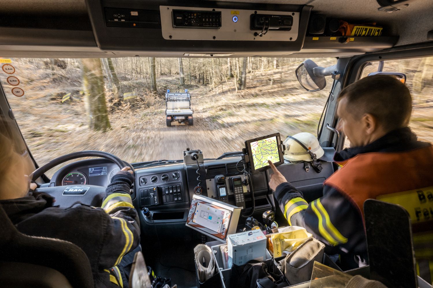 Blick durch Frontscheibe eines Feuerwehrautos im Wald